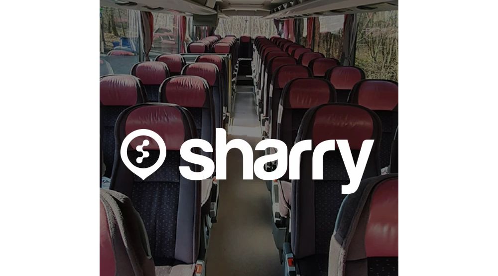 логотип і назва компанії Sharry на фоні чорно-червоного салону автобуса