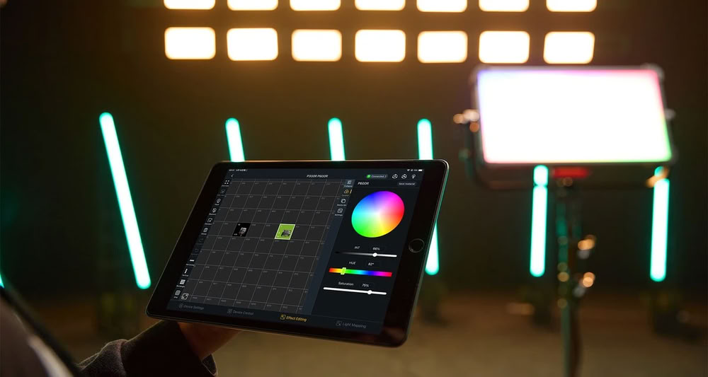 Гафер тримає планшет із додатком Godox KNOWLED і режимом Light Mapping, позаду на стійці працює кінопанель P300R та бірюзові трубки в зоні розмиття